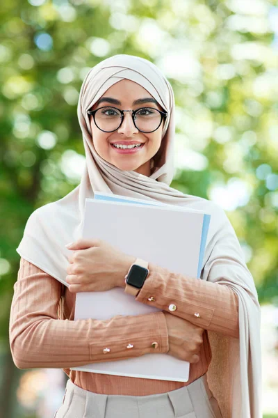 Alegre feliz lindo joven árabe musulmán estudiante en hijab y gafas sostiene libros, listo para la conferencia — Foto de Stock