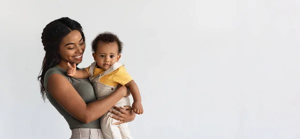 Концепция материнства. Молодая чернокожая мать держит на руках спящего младенца — стоковое фото