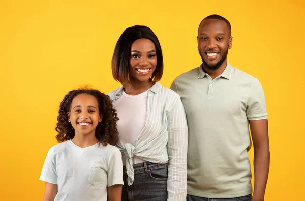 Mensen, familie portait concept. gelukkig afrikaanse amerikaanse man, vrouw en meisje poseren voor foto en glimlachen naar camera — Stockfoto