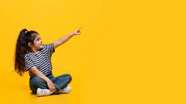 Şuna bak. Sevimli küçük Arap kız yerde oturuyor ve onu işaret ediyor.