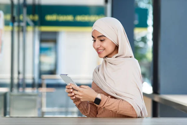 Mosolygó aranyos fiatal arab iszlám nő hidzsáb sms üzenet, ellenőrzése app és a szociális média — Stock Fotó