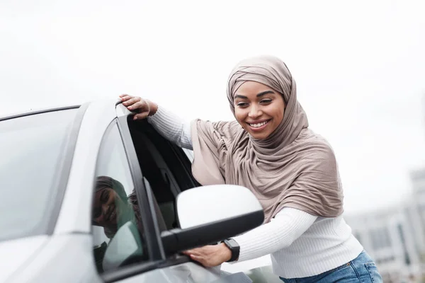 Tatmin olmuş, tatlı, Afro-Amerikan, tesettürlü bayan müşteri yeni arabalara dokunuyor, satın almaktan keyif alıyor. — Stok fotoğraf