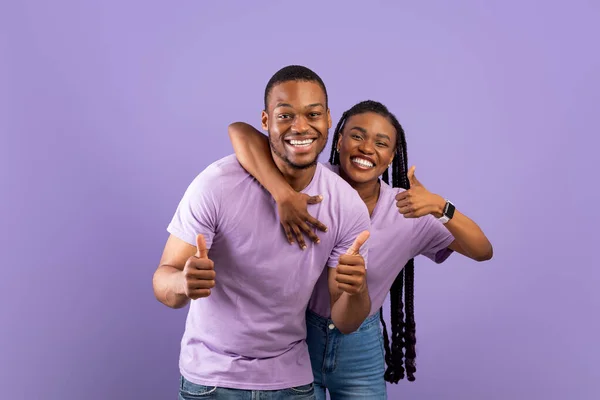 Glückliches schwarzes Paar gestikuliert mit erhobenen Daumen und lächelt — Stockfoto