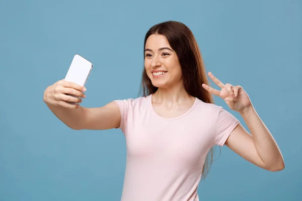 Alegre mujer joven de pelo justo tomando selfie en el teléfono celular — Foto de Stock