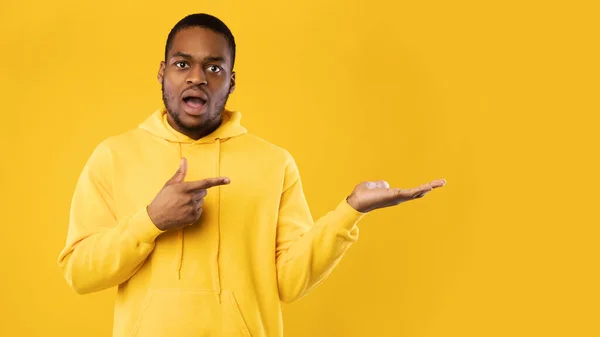 Shocked negro hombre señalando dedo mostrando espacio de copia, fondo amarillo — Foto de Stock