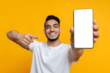 Mutlu Arap adam boş ekranlı cep telefonunu işaret ediyor.