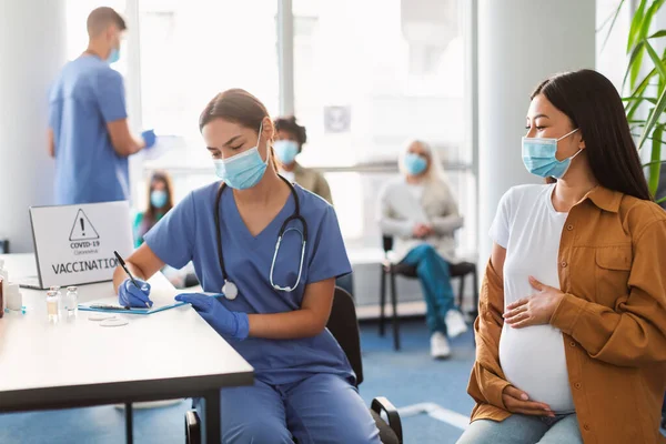 Doktor má schůzku pro vakcinaci na usmívající se těhotné dámy — Stock fotografie