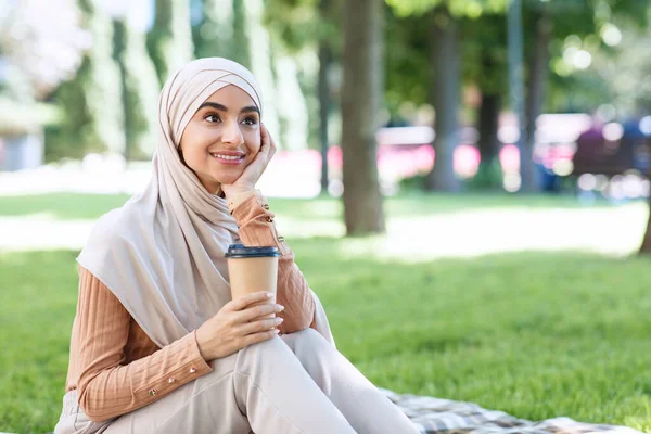 Usmívající se tisíciletá arabská muslimka studentka v hidžábu si dá pauzu od práce nebo studia, odpočine si v parku — Stock fotografie