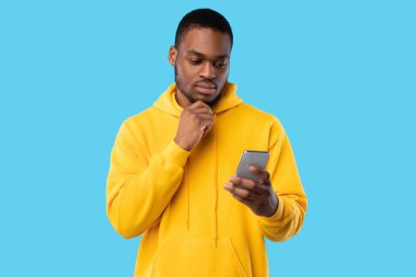 Afrikalı Amerikalı Adam Akıllı Telefon Tutuyor Mesaj ve Düşünme, Mavi Arkaplan