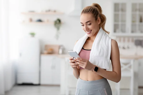 Feliz europeu bonito millennial loira feminino verificando aplicativo de fitness ou mídia social no smartphone — Fotografia de Stock