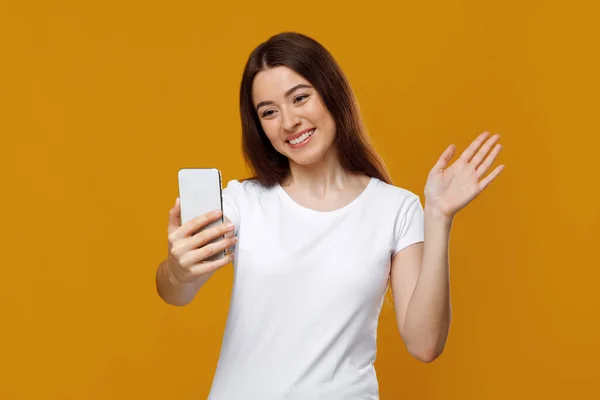 Señora bonita positiva saludando en la pantalla del teléfono inteligente — Foto de Stock