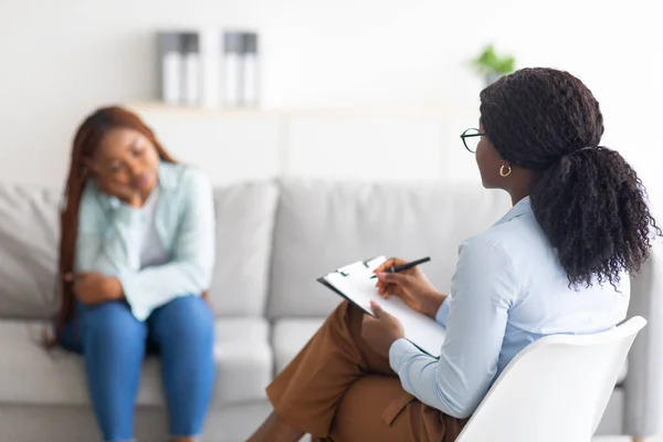 Depressed black lady receiving professional psychological help at mental clinic, selective focus — Stock Photo, Image