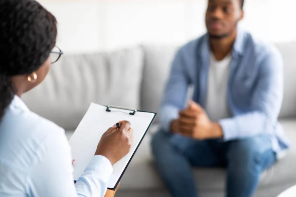 Jonge zwarte man met depressie of PTSS die sessie met psychotherapeut in kliniek, selectieve focus — Stockfoto