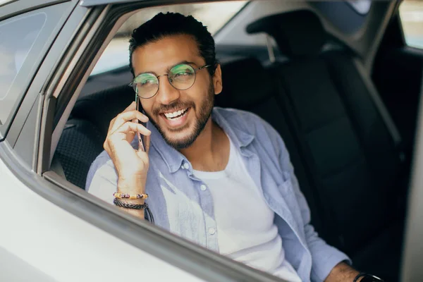 Positiv arabisk kille som tar taxi, pratar i telefon — Stockfoto