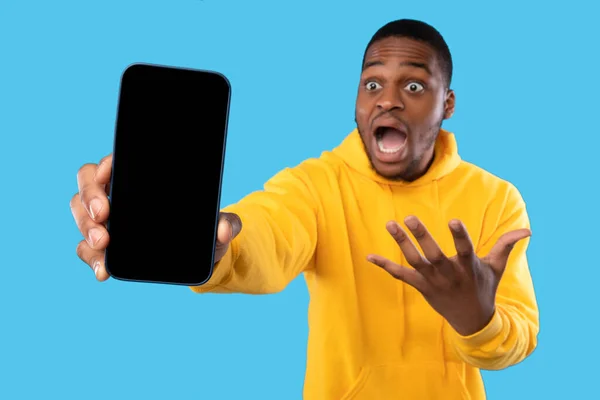 감정적 흑인 이 스마트폰을 보여 빈 화면, 블루 백 그라운드 — 스톡 사진