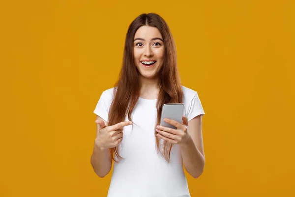 Verbazingwekkende mooie vrouw wijzen naar smartphone in haar hand — Stockfoto