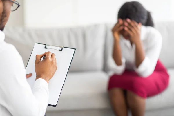 Infeliz joven negra llorando en consulta con psicoterapeuta en la clínica —  Fotos de Stock