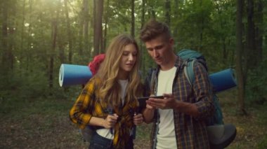 Çevrimiçi navigasyon. Doğru yolu bulmak için cep telefonunda harita uygulaması kullanan iki genç turist.