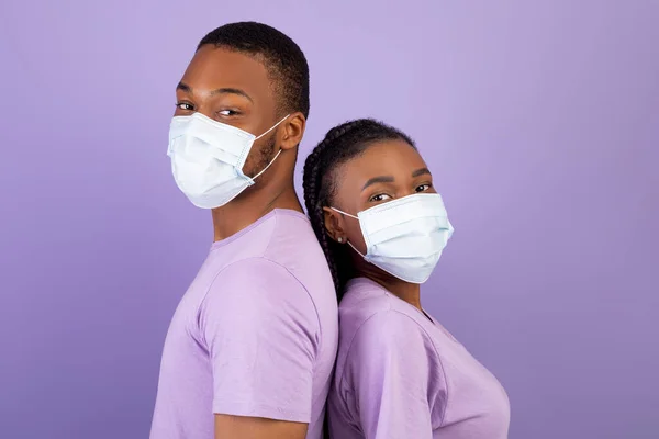 Africano casal americano em máscara de pé no estúdio — Fotografia de Stock