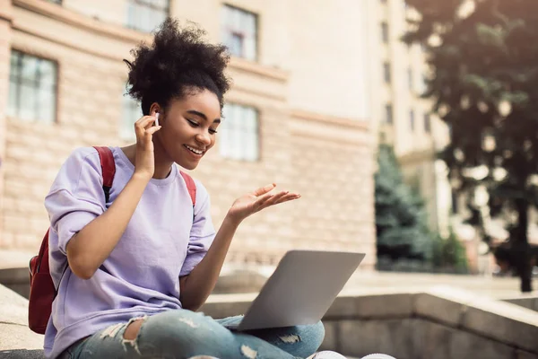 Chica africana hablando con el ordenador portátil que tiene clases en línea al aire libre — Foto de Stock