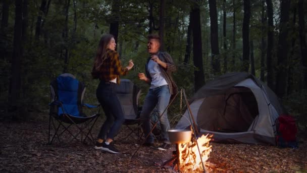 Feliz casal de lazer. Jovem homem positivo e mulher dançando na floresta, curtindo fins de semana de acampamento ativos — Vídeo de Stock