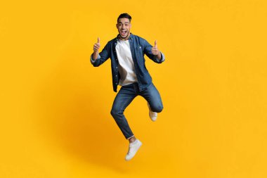 Duygusal Arap adam zıplıyor ve baş parmağını kaldırıyor.