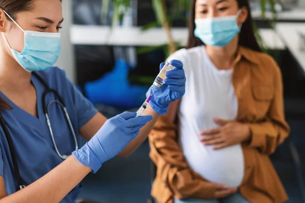 Lékař užívající dávku Covid-19 vakcíny pro těhotnou ženu — Stock fotografie