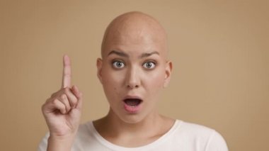Kel Saçlı Kadın Parmağını İşaret Ediyor Bej Arkaplan Üzerinde Fikri Var