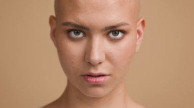 Bej Arkaplan Üzerinde Ciddi Kılsız Kadın Portresi