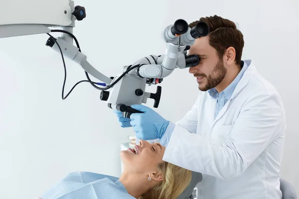 Stomatoloog op zoek naar tandheelkundige microscoop, met behulp van innovatieve tools — Stockfoto