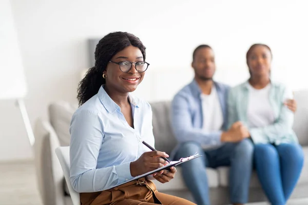 Portrait d'une conseillère conjugale noire au bureau après une séance efficace avec un jeune couple marié, espace de copie — Photo