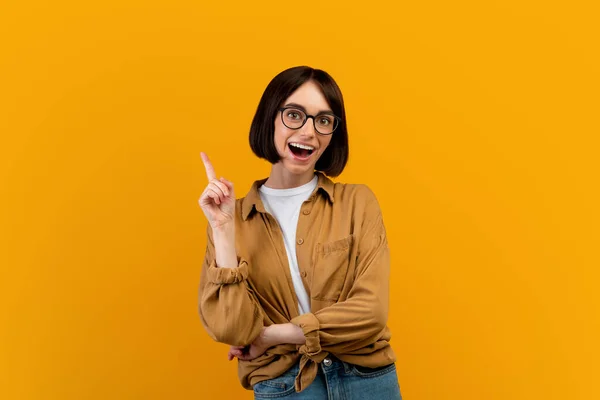 Ich habe eine Idee. Emotionale Dame, die große Gedanken hat, Inspiration oder Lösung für ein Problem findet, gelber Hintergrund — Stockfoto