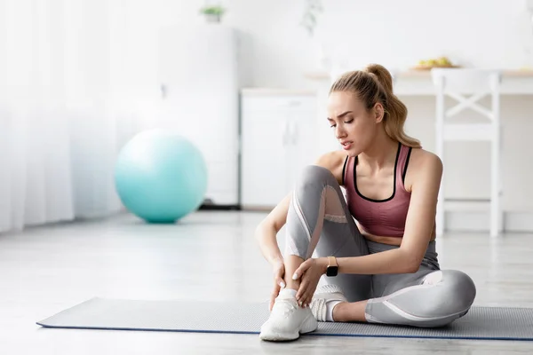 Depresión caucásica joven rubia mujer que sufre de dolor, sensación de dolor en la pierna después del entrenamiento —  Fotos de Stock