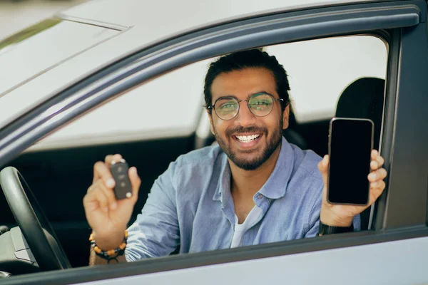 자동차 키와 스마트폰을 보여 주는 쾌활 한 중동 남자, 박수치며 — 스톡 사진