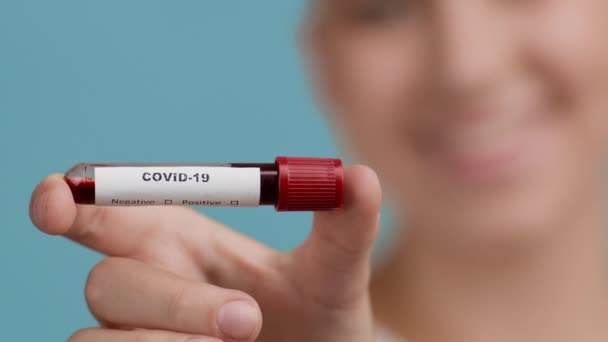 陰性のPCR検査で血液コンテナを示す回復女性, Studio — ストック動画