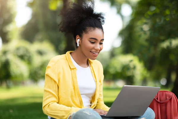 Chica estudiante negro hablando con la cámara web del ordenador portátil durante Webinar al aire libre — Foto de Stock