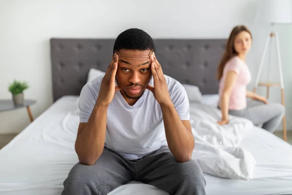 Sexuella problem, relationskris. Stressad svart kille sitter på sängen, massera tempel, trött på familjesvårigheter — Stockfoto