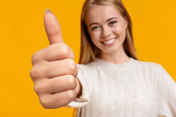 Симпатична дівчина-підліток показує великий палець на жовтому — стокове фото