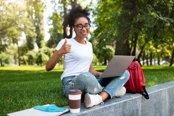 Africana estudiante chica gestos como posando con portátil al aire libre — Foto de Stock