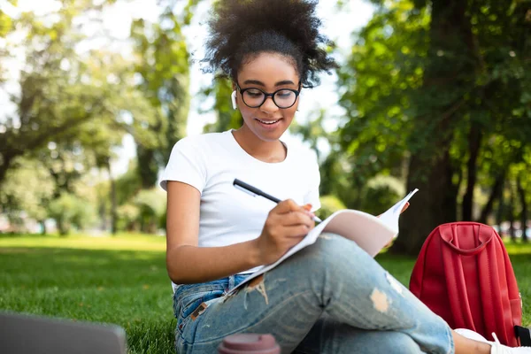 Afrikalı Öğrenci Kız Laptop Öğreniyor ve Dışarıda Not Tutuyor — Stok fotoğraf