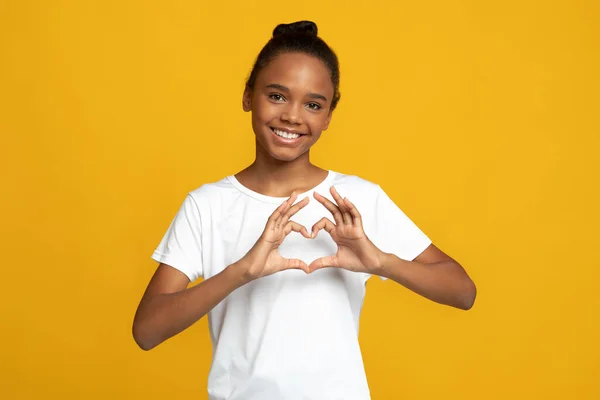 ハッピーティーンアフリカ系アメリカ人女の子学生ブロガーでホワイトtシャツショー心ジェスチャーとともに手 — ストック写真