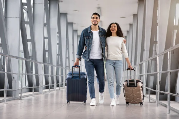พร้อมสําหรับวันหยุด คู่รักโรแมนติกตะวันออกกลาง เดินพร้อมกระเป๋าเดินทางที่อาคารผู้โดยสารสนามบิน — ภาพถ่ายสต็อก