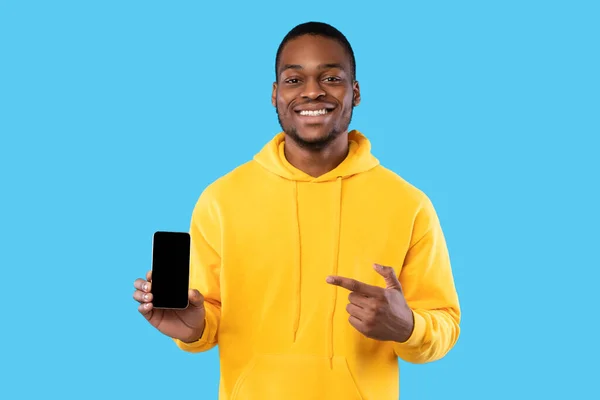 African Guy Visar telefon med tom skärm på blå bakgrund — Stockfoto