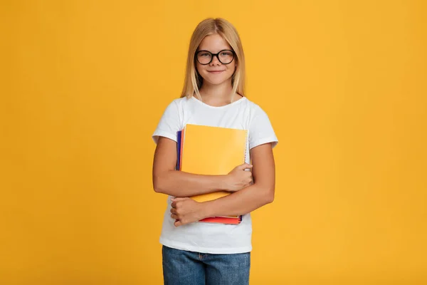 Glimlach adolescent europees dame schoolmeisje in wit t-shirt en bril hold boeken, klaar om te studeren — Stockfoto