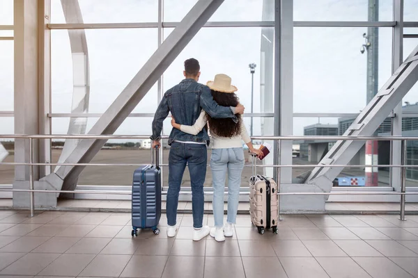 Vista trasera de pareja romántica mirando por la ventana en la terminal del aeropuerto —  Fotos de Stock