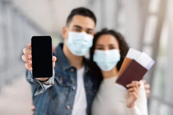 의료계의 아랍 부부가 검은 화면으로 스마트폰을 보여 달라고 요청하는 장면 — 스톡 사진