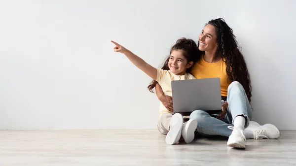 Great Offer. Happy Little Girl And Her Mom With Laptop Pointing Aside — Stock Photo, Image