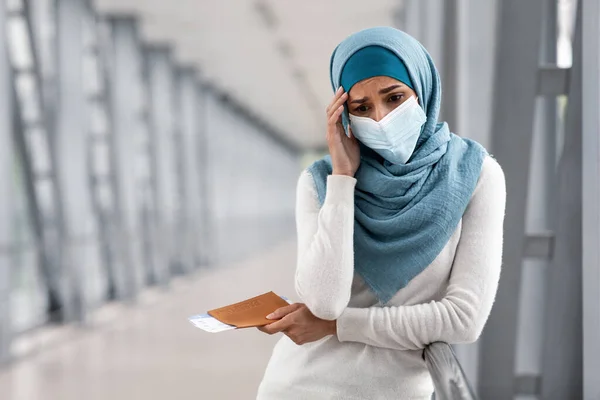 Vuelo cancelado. Deprimida mujer islámica en máscara y hiyab de pie en el aeropuerto —  Fotos de Stock