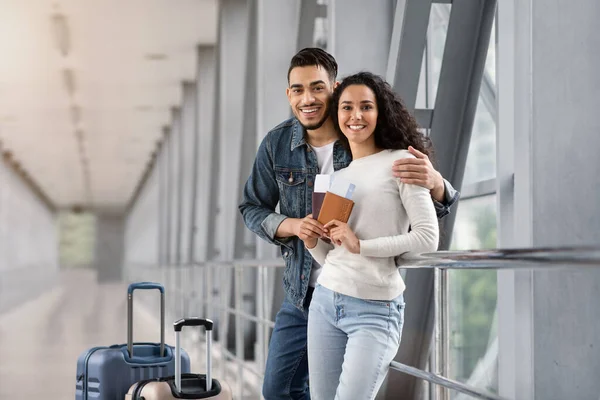 Felici sposi arabi in posa nel terminal dell'aeroporto, guardando la fotocamera e sorridendo — Foto Stock