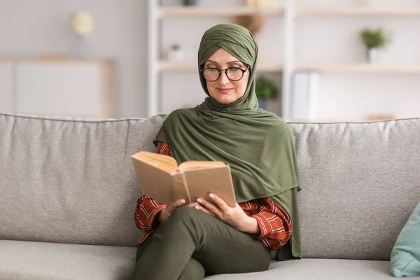 Boldog Senior iszlám hölgy olvasás könyv visel szemüveg otthon — Stock Fotó